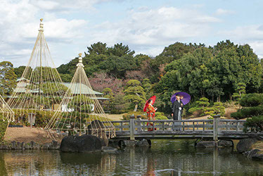 肥後細川庭園の門前で手を取り合い微笑む新郎新婦