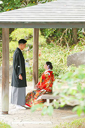 肥後細川庭園にかかる橋の上で和傘を持ちポーズをとる新郎