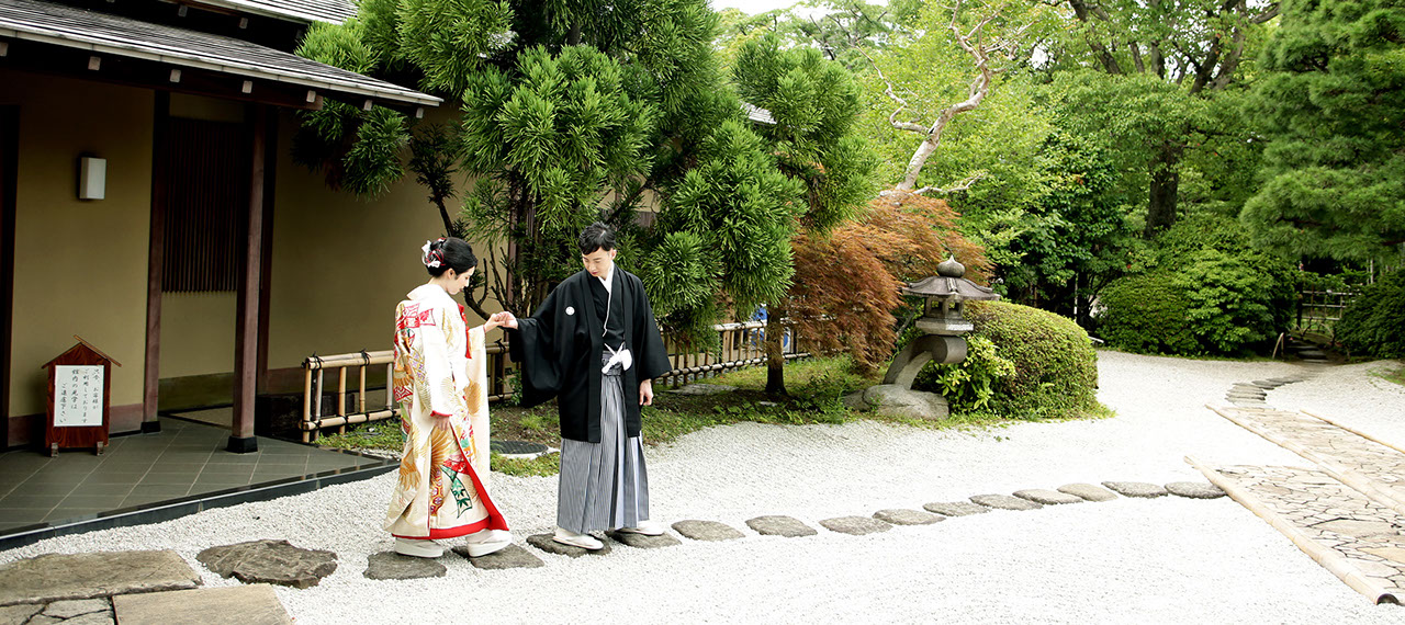 枯山水の庭を手を引いて歩く新郎新婦