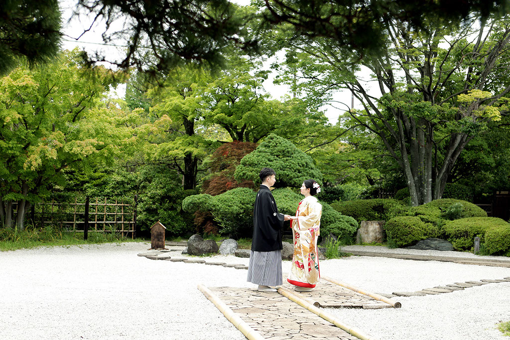 枯山水の上で微笑む合う新郎新婦