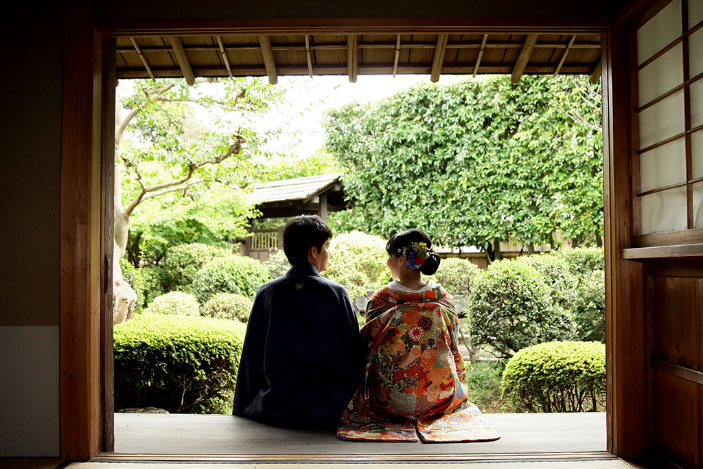 涼しい和室から庭を眺める新郎新婦